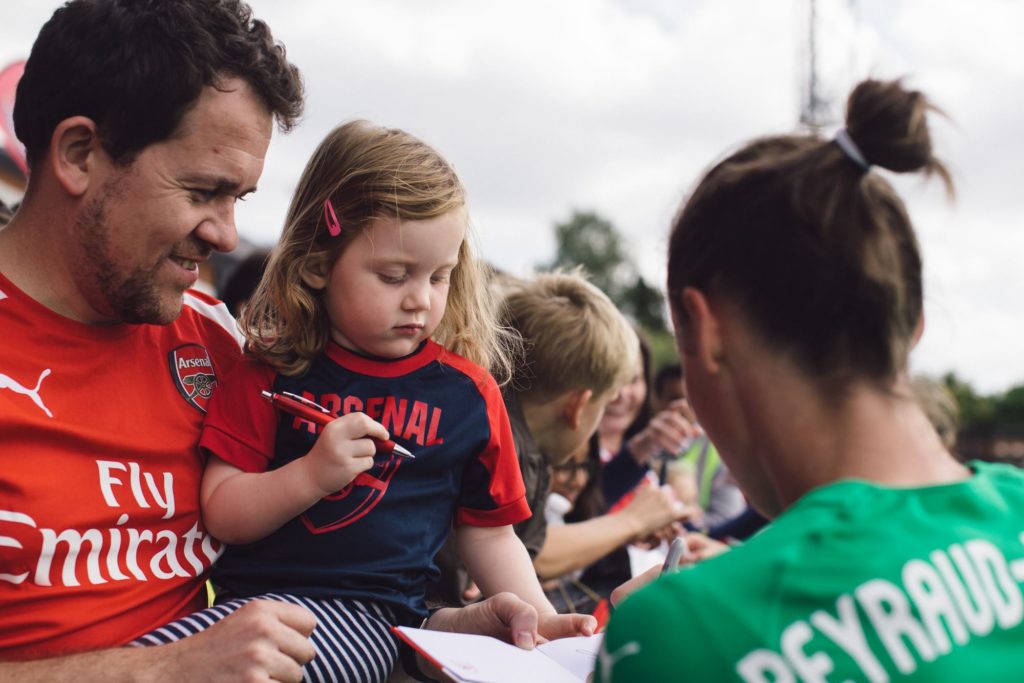 Pauline qui signe quelques autographes à des fans d'Arsenal FC