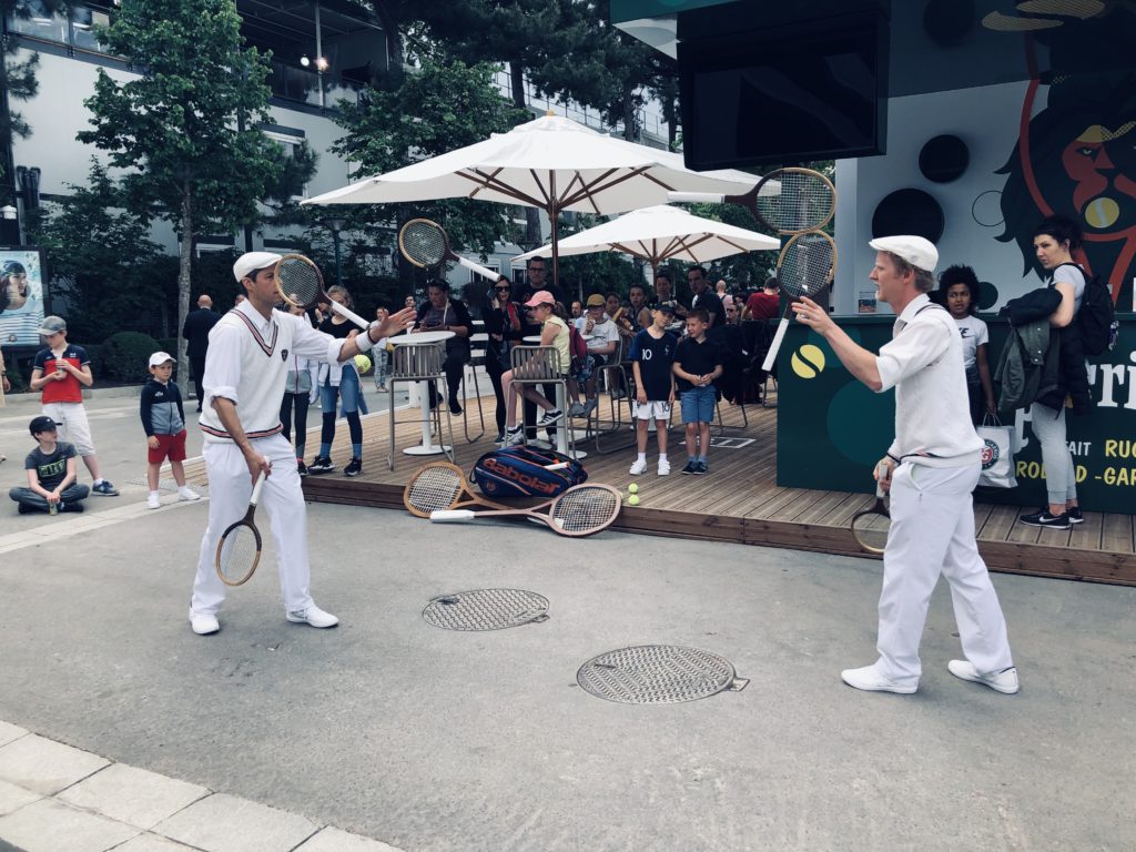 Des jongleurs et musiciens se déplacent dans l'enceinte de Roland-Garros