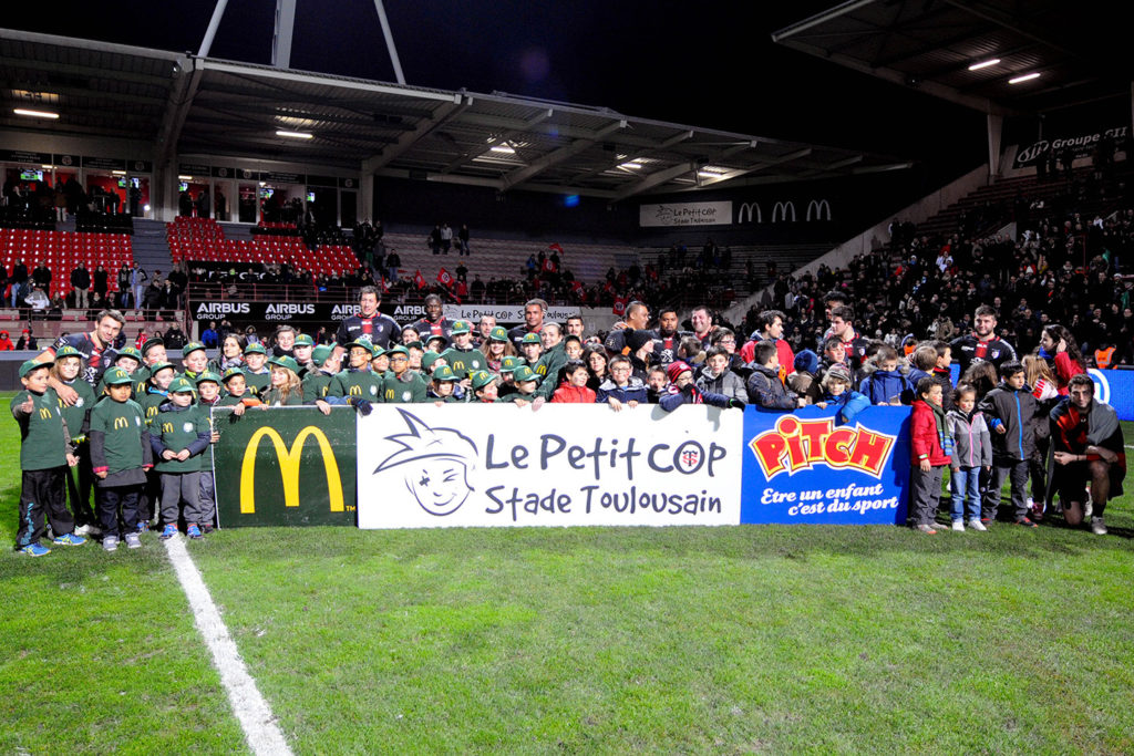 Les enfants du Petit Cop qui posent avec les joueurs au stade Ernest Wallon